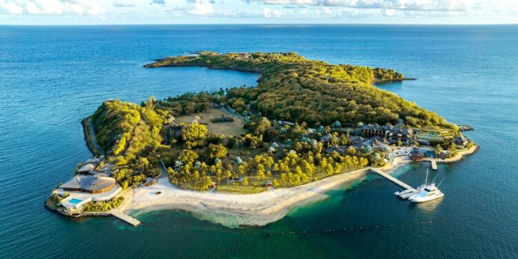 Resor pulau hijau subur yang dikelilingi oleh air laut biru jernih.
